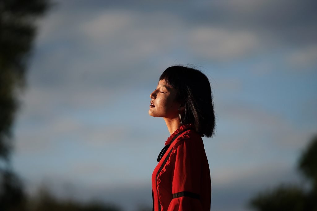 side view young woman standing against sky scaled